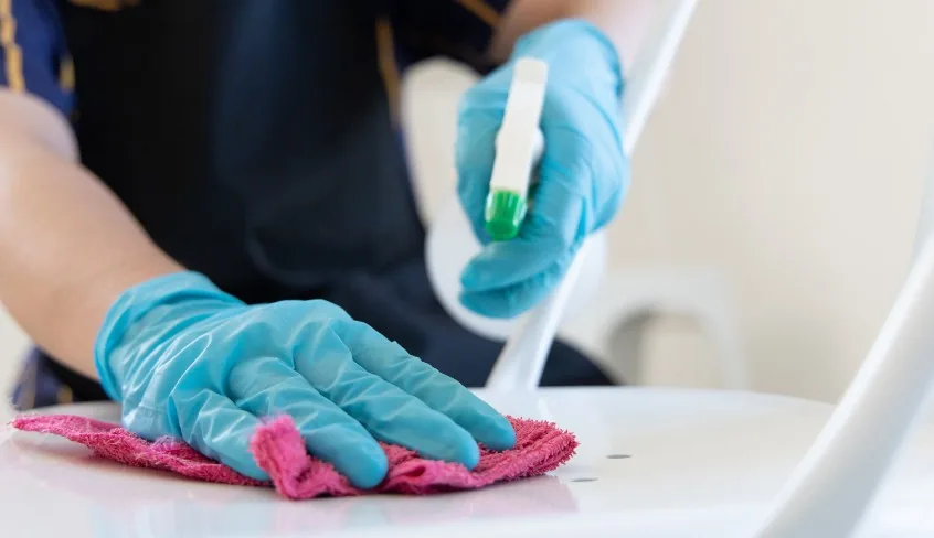 Desinfección de una superficie con pulverizador y bayeta de microfibra, con guantes de nitrilo